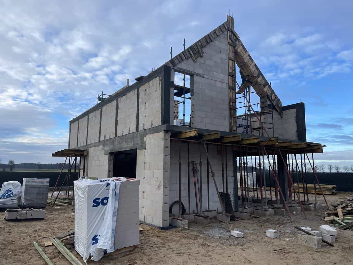 Stan surowy otwarty domu — ściany z bloczków i konstrukcja dachu z rusztowaniami