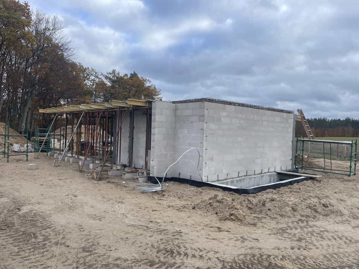 Boczna elewacja domu z oknami na parterze i piętrze