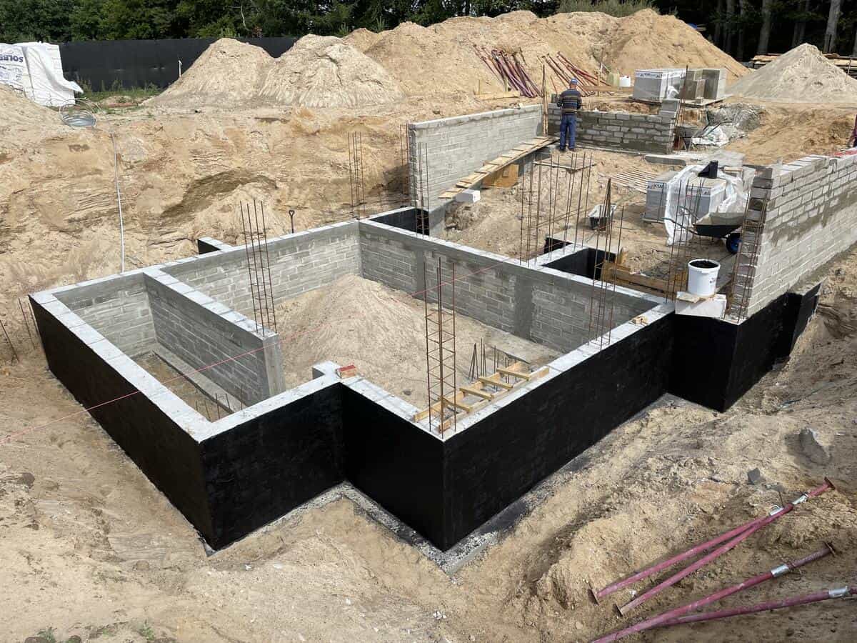 Prace fundamentowe — ściany piwnicy z hydroizolacją i zbrojeniem