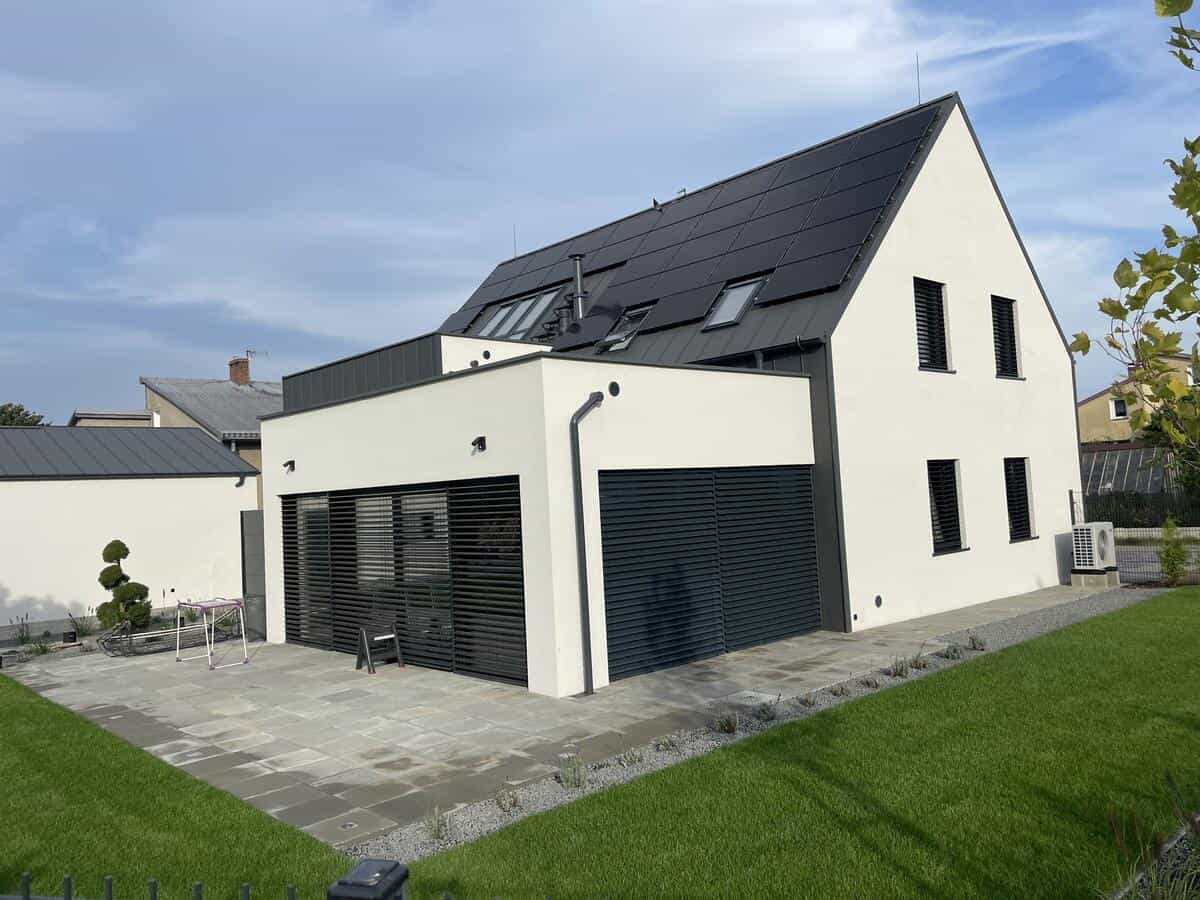 Elewacja frontowa budynku z kontrastującymi biało-ciemnymi ścianami