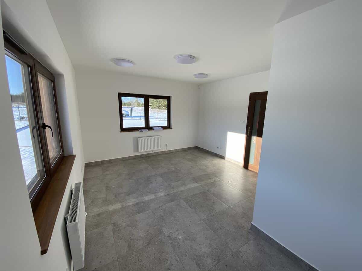 Przestronne pomieszczenie biurowe z grzejnikami i dużymi oknami