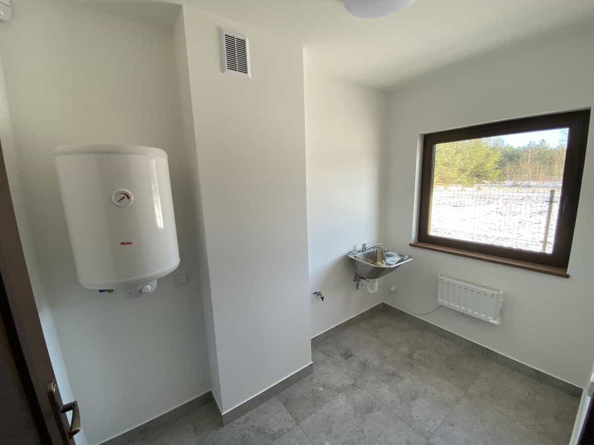 Korytarz kancelarii z jasnymi ścianami i posadzką gresową