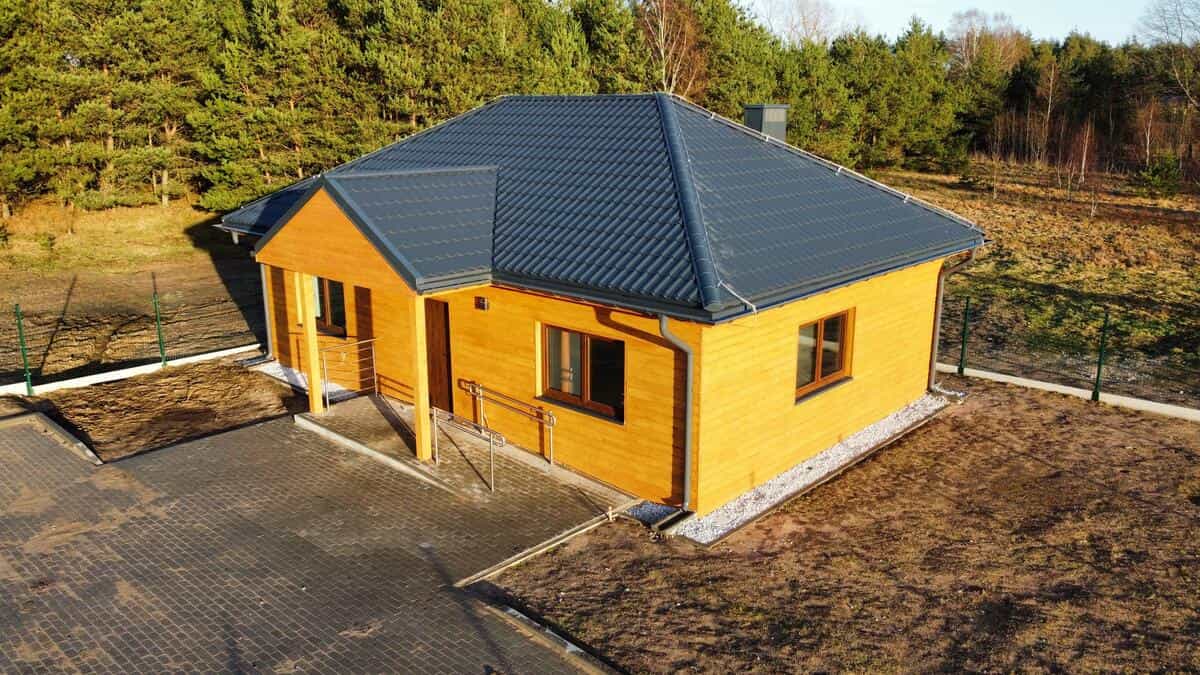 Widok na budynek z poziomu terenu — otoczenie leśne