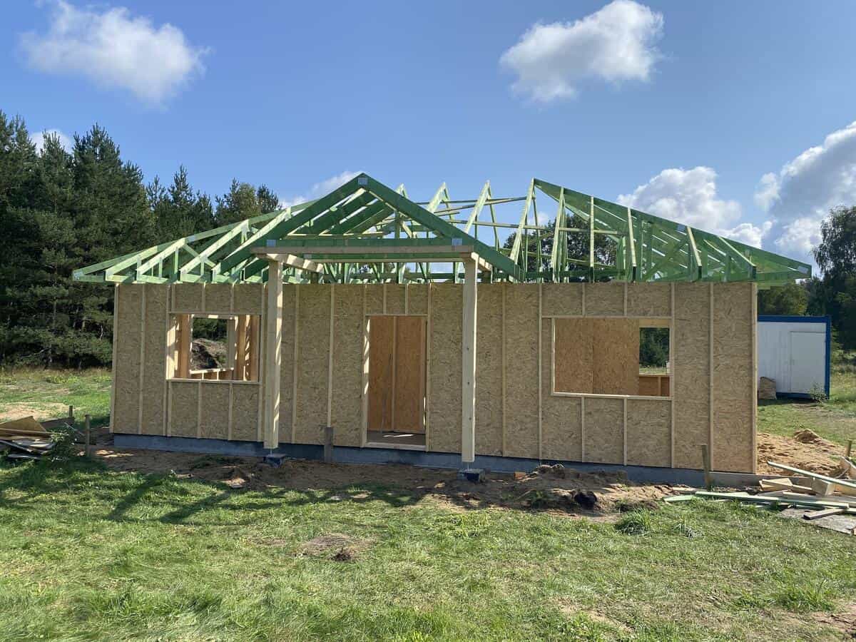 Widok boczny kancelarii z widoczną konstrukcją dachową i rusztowaniami